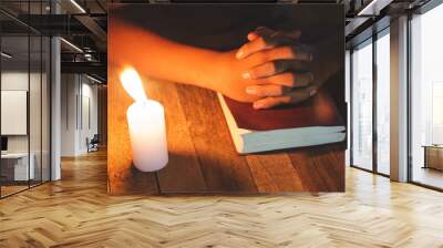 Hand boy praying In the room and lit candles to light , Hands folded in prayer concept for faith, spirituality and religion Wall mural