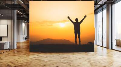 Man rise hand up on top of mountain and sunset,  Freedom and travel adventure concept. Religious beliefs, Copy space. Wall mural