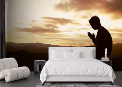 silhouette of a man is praying to god on the mountain. praying hands, pay respect. Wall mural