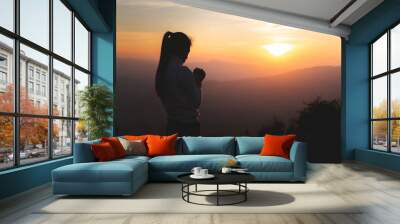 Silhouette of young  human hands  praying to god  at sunrise, Christian Religion concept background. Wall mural