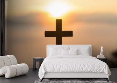 Silhouette of young  human hands praying with a  cross at sunrise, Christian Religion concept background. Wall mural