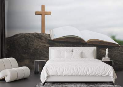 The cross and the bible is on the rock.Worship, sins and prayer. Wall mural