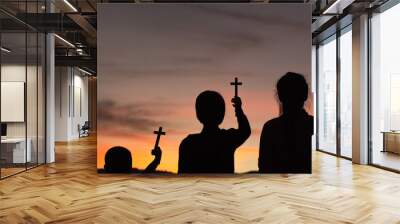 Three children worship God by holding christian Cross  with light sunset background, christian concept. Wall mural