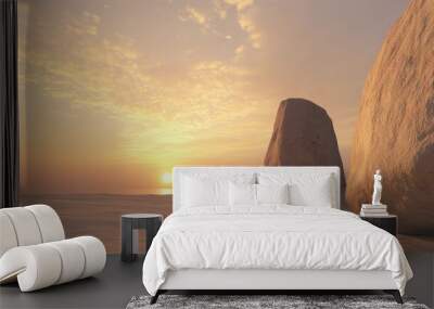 Three large rocks stand on a sandy beach at sunset. The sun is setting in the distance behind the rocks. The sky is a beautiful orange and pink color. Wall mural