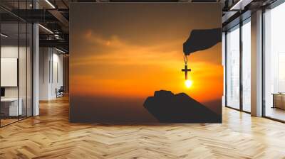 Women standing holding holy  bible and the crucifix for worshipping God at sunset background, Pray to the god, christian silhouette concept. Wall mural