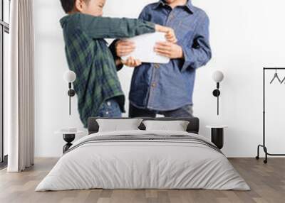 Two boy grab and competition to get tablet device Wall mural