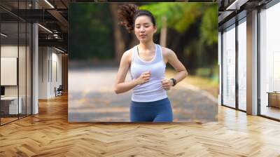 Young woman running in a park Wall mural