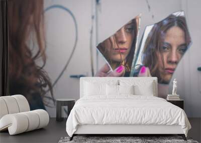 Beautiful girl looking at herself in a mirror Wall mural