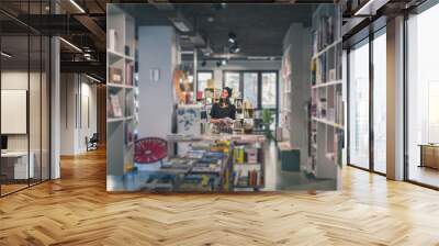 Beautiful young brunette posing in a bookstore Wall mural