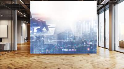 Business finance and investment concept. Double exposure of businessman working on laptop computer and the city with financial graph for business and technology background Wall mural