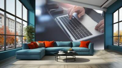 Business man working on laptop computer at modern loft office. Man using computer notebook, typing on keyboard, surfing the internet, online working at home office, E-learning Wall mural