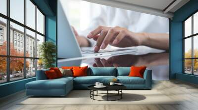 Close up of business woman hand typing on laptop computer keyboard with reflection on digital tablet on office table, online working, surfing the internet, distant job, remote work concept Wall mural