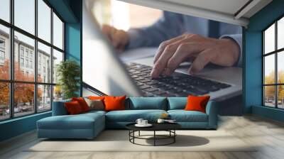 Close up of businessman working on laptop computer in office Wall mural