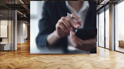 Close up of businesswoman using mobile smart phone and digital tablet computer at office. Asian business woman hand holding smartphone, connecting the internet, online working, corporate business Wall mural