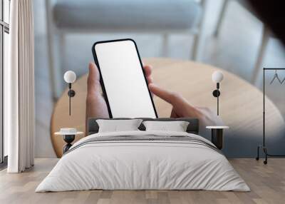 Mockup, using cell phone in a cafe coffee shop. Woman holding using smartphone with blank screen for display your graphic ads, mobile app. close-up  Wall mural