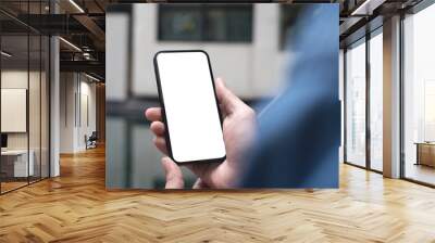 Mockup image of mobile phone for advertising. Mock up image of man hand holding and using smartphone with blank screen for mobile app design or text advertisement Wall mural