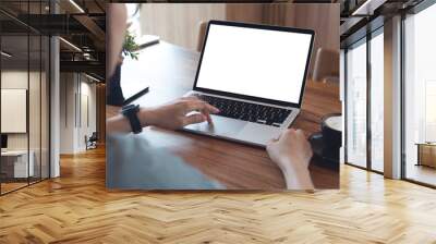 Mockup laptop computer. Business woman using laptop with empty screen on wooden table in modern loft cafe. Back view Wall mural