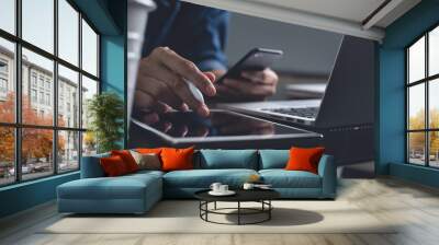 Multitasking businessman working on computer devices at home office Wall mural