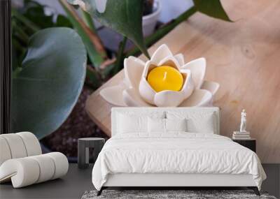 A beeswax tealight candle is inside of a flower shaped holder. Wall mural