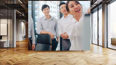 Asia businessmen and businesswomen meeting brainstorming ideas conducting business presentation project colleagues working together plan success strategy enjoy teamwork in small modern office. Wall mural