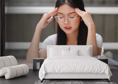 Asian student women read books in library at university. Young undergraduate girl stress tired have problem while study hard for knowledge on lecture desk at college campus concept. Wall mural