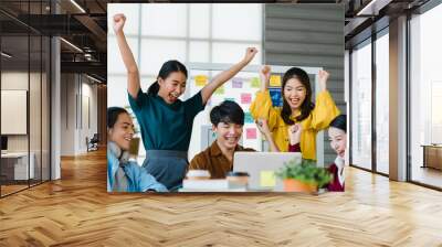 Group of Asia young creative people in smart casual wear discussing business celebrate giving five after dealing feeling happy and signing contract or agreement in office. Coworker teamwork concept. Wall mural