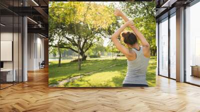 Healthy young Asian runner woman warm up the body stretching before exercise and yoga near lake at park under warm light morning. Lifestyle fitness and active women exercise in urban city concept. Wall mural