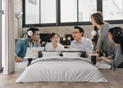 Multiracial group of young creative people in casual wear meeting brainstorming ideas about new paperwork project colleagues working together planning success strategy enjoy teamwork in small office Wall mural