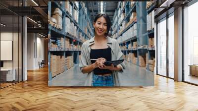 Portrait of attractive young Asia businesswoman manager smiling charmingly looking at camera hold digital tablet stand in retail shopping center. Distribution, Logistics, Packages ready for shipment. Wall mural