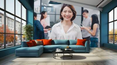 Portrait of successful beautiful executive businesswoman smart casual wear looking at camera and smiling, happy in modern office workplace. Young Asia lady standing relax in contemporary meeting room. Wall mural