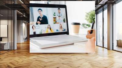 Young Asia businesswoman using laptop talk to colleague about plan in video call meeting while work from home at living room. Self-isolation, social distancing, quarantine for corona virus prevention. Wall mural