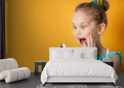 Cute little girl eats ice cream in studio Wall mural