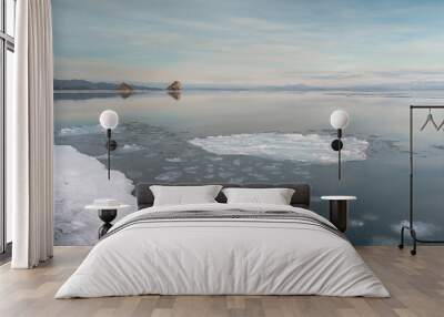 Winter seascape. Two rocks protruding from the mirror surface of the sea. Mirror surface of water and rocks in the distance. Wall mural