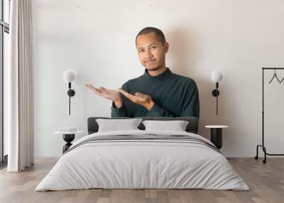 Young Adult Asian men showing to the left with smiling face and exited expression with isolated white background Wall mural