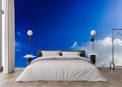 Deep blue sunny sky with white clouds. Blue sky with cloud closeup. White fluffy clouds in the blue sky. Wall mural