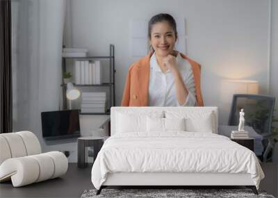 portrait of beautiful young Asian business woman standing while smiling looking at camera in the office Wall mural