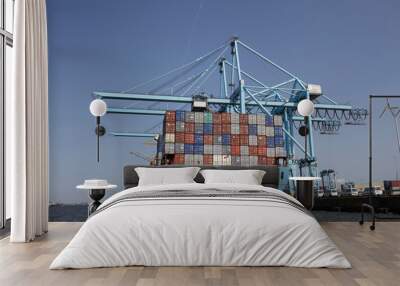 Large harbor cranes loading container ships in the port of Rotterdam. Wall mural