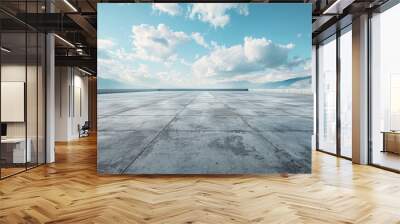 A large empty parking lot with a clear blue sky above Wall mural