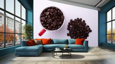 Coffee beans in a red cup on a light background Wall mural