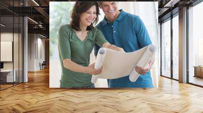 woman showing blueprint to husband in new house Wall mural