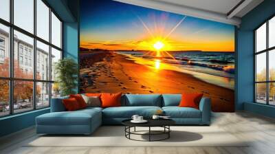 Vibrant sunrise over a peaceful beach with a golden reflection on the water. Wall mural