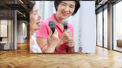  Elderly woman sing a song with daughter at home. Wall mural