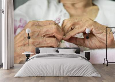 Elderly woman fasten buttons on dress , progressive brain disorder ,Close up hand Wall mural