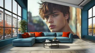 Young man with trim hair poses in urban setting. Wall mural