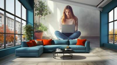 Young woman on floor with laptop. Wall mural