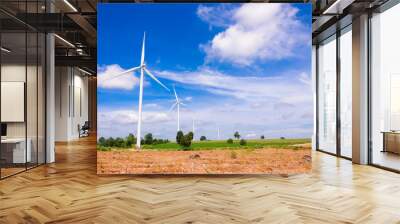 Wind turbine on the green meadow over the blue clouded sky Wall mural