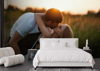 Romantic Couple at Sunset. Two people in love at sunset or sunrise. Man and woman on field Wall mural