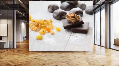 two pieces of black chocolate and a wallnut on it. Wall mural