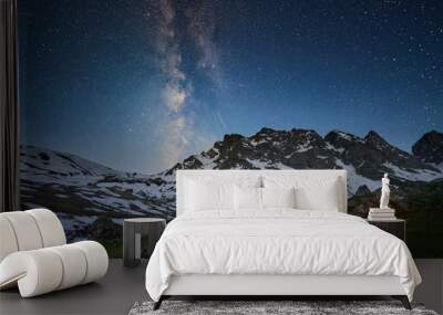 Couple standing near tent and looking at the milky way in mountains at night Wall mural