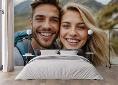 Close-up selfie of a cheerful young white couple with backpacks, smiling in the great outdoors, exuding warmth and happiness on their hiking adventure. Wall mural